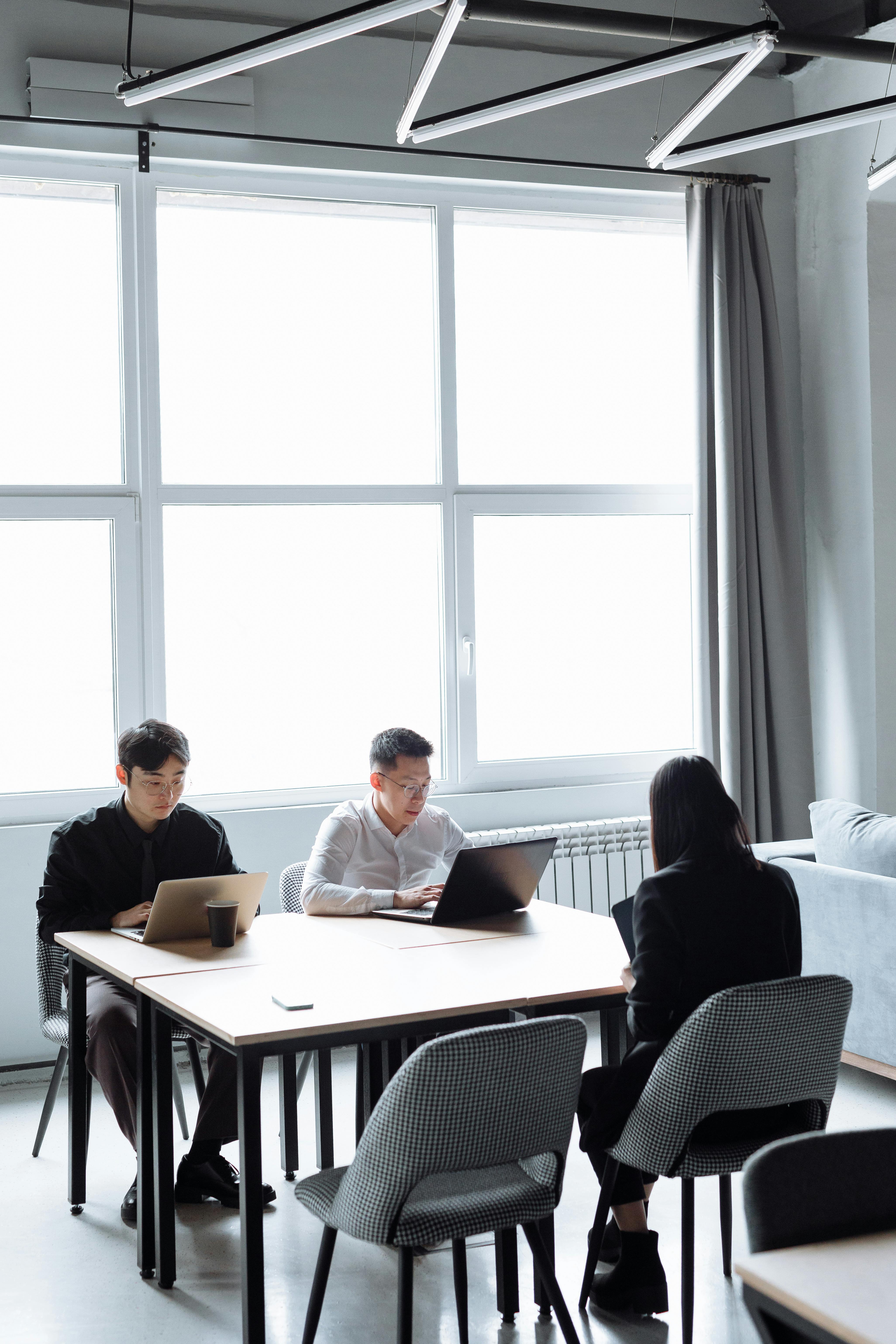 Warm human-centered workspace detail with laptop and materials.
